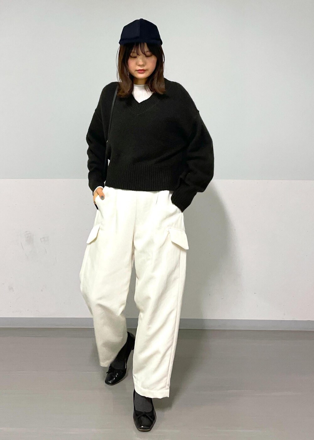 ブラウン系のニット/セーター、ホワイト系のカーゴパンツ、ホワイト系のTシャツ/カットソーを着用したレディースの冬コーディネートの3枚目の写真