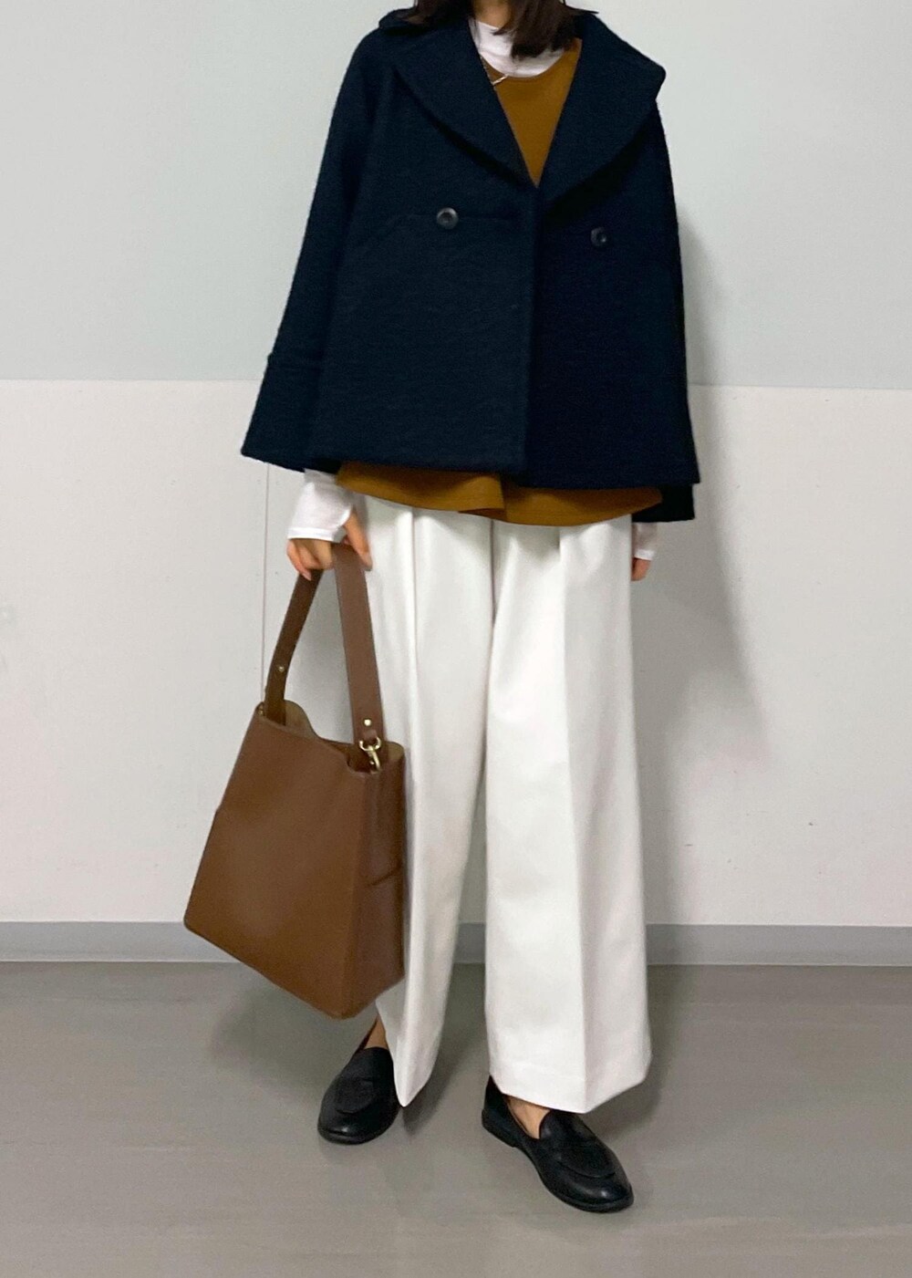 ブルー系のピーコート、ブラウン系のTシャツ/カットソー、ホワイト系のその他パンツを着用したレディースの秋コーディネートの7枚目の写真