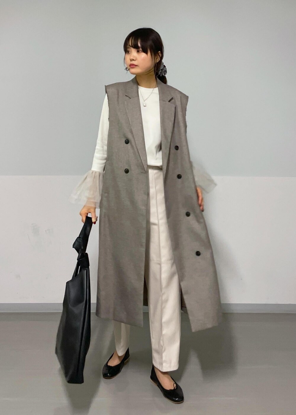 ベージュ系のジャンパースカート、ホワイト系のTシャツ/カットソー、ブラック系のバレエシューズを着用したレディースの秋コーディネートの10枚目の写真