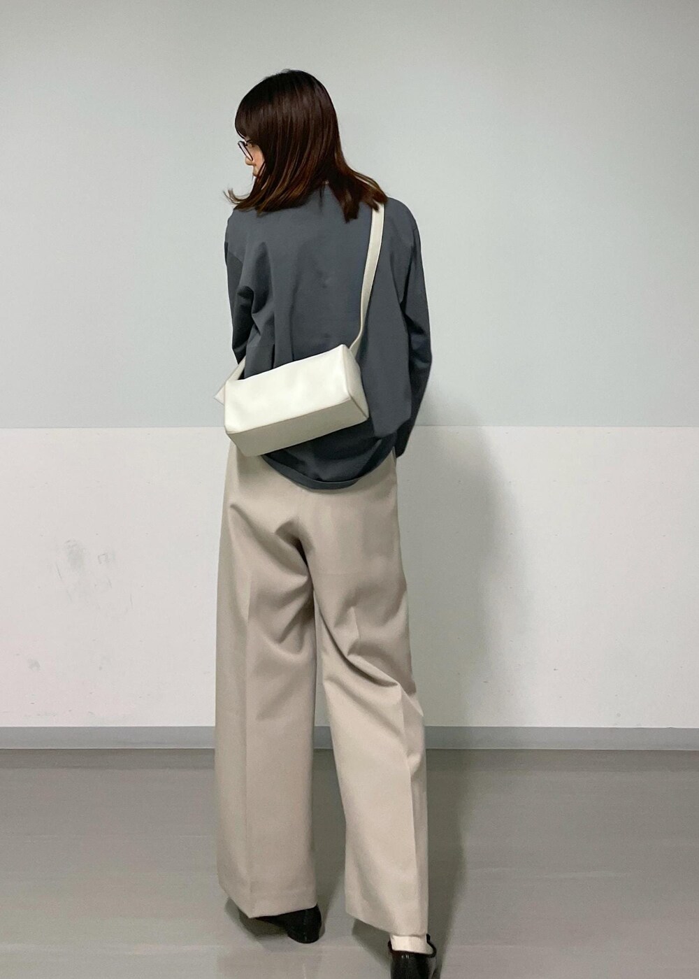 グレー系のショルダーバッグ、ベージュ系のその他パンツ、グレー系のTシャツ/カットソーを着用したレディースの秋コーディネートの2枚目の写真