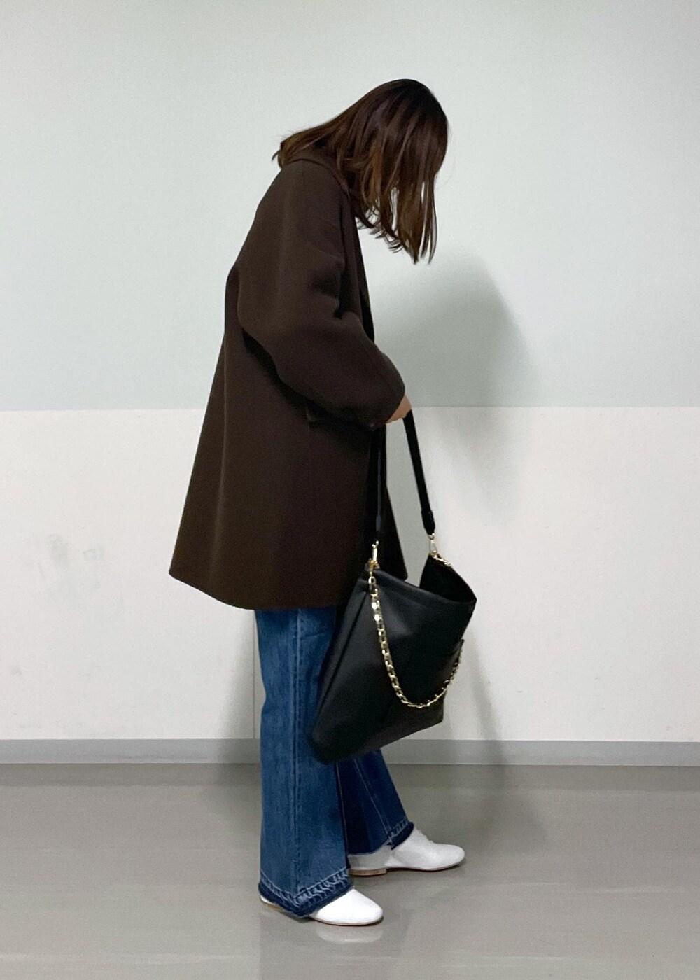 ブラウン系のピーコート、ブラック系のトートバッグ、ブラウン系のTシャツ/カットソーを着用したレディースの冬コーディネートの7枚目の写真