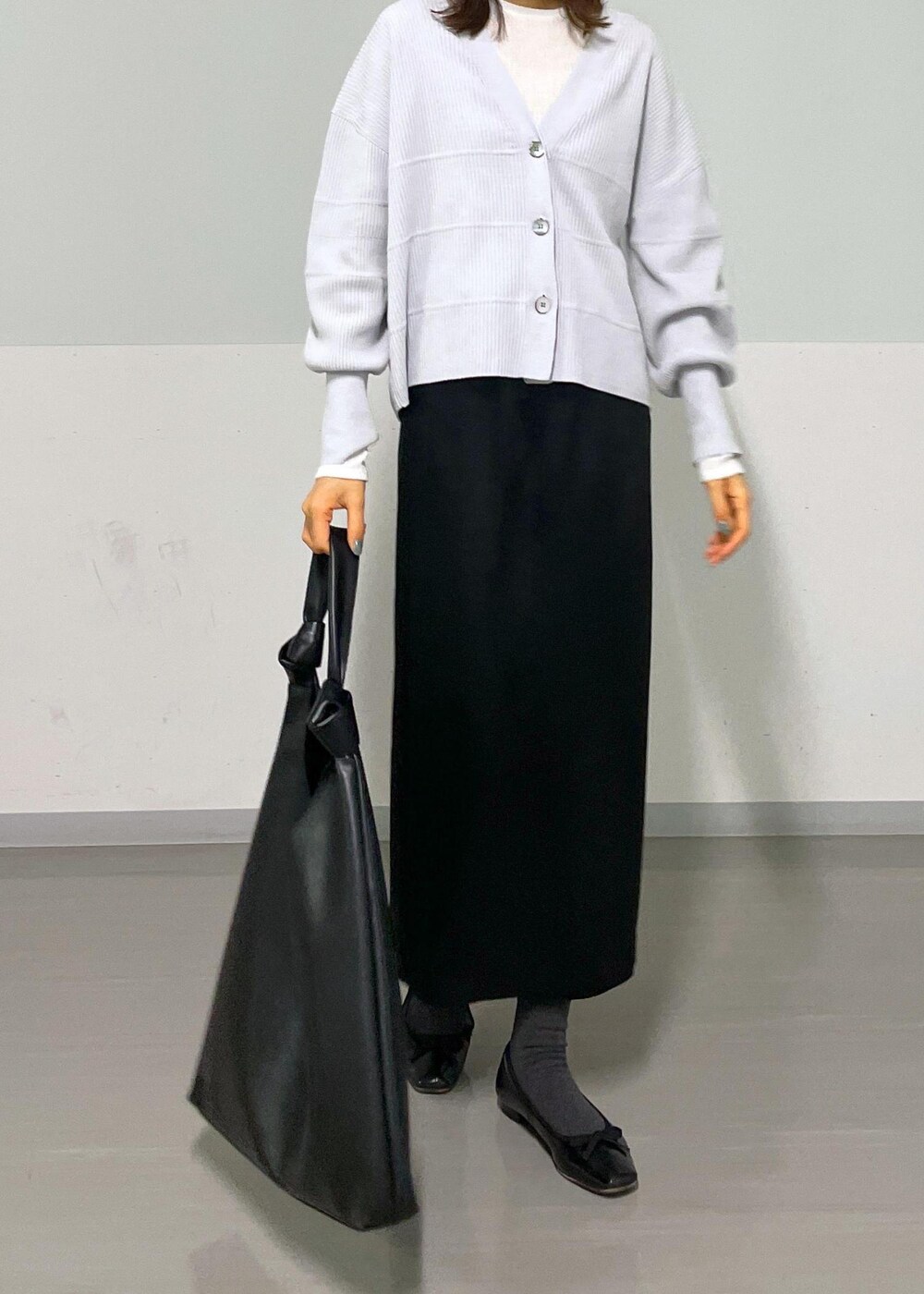 ブラック系のトートバッグ、ホワイト系のTシャツ/カットソー、グレー系のカーディガン/ボレロを着用したレディースの冬コーディネートの8枚目の写真