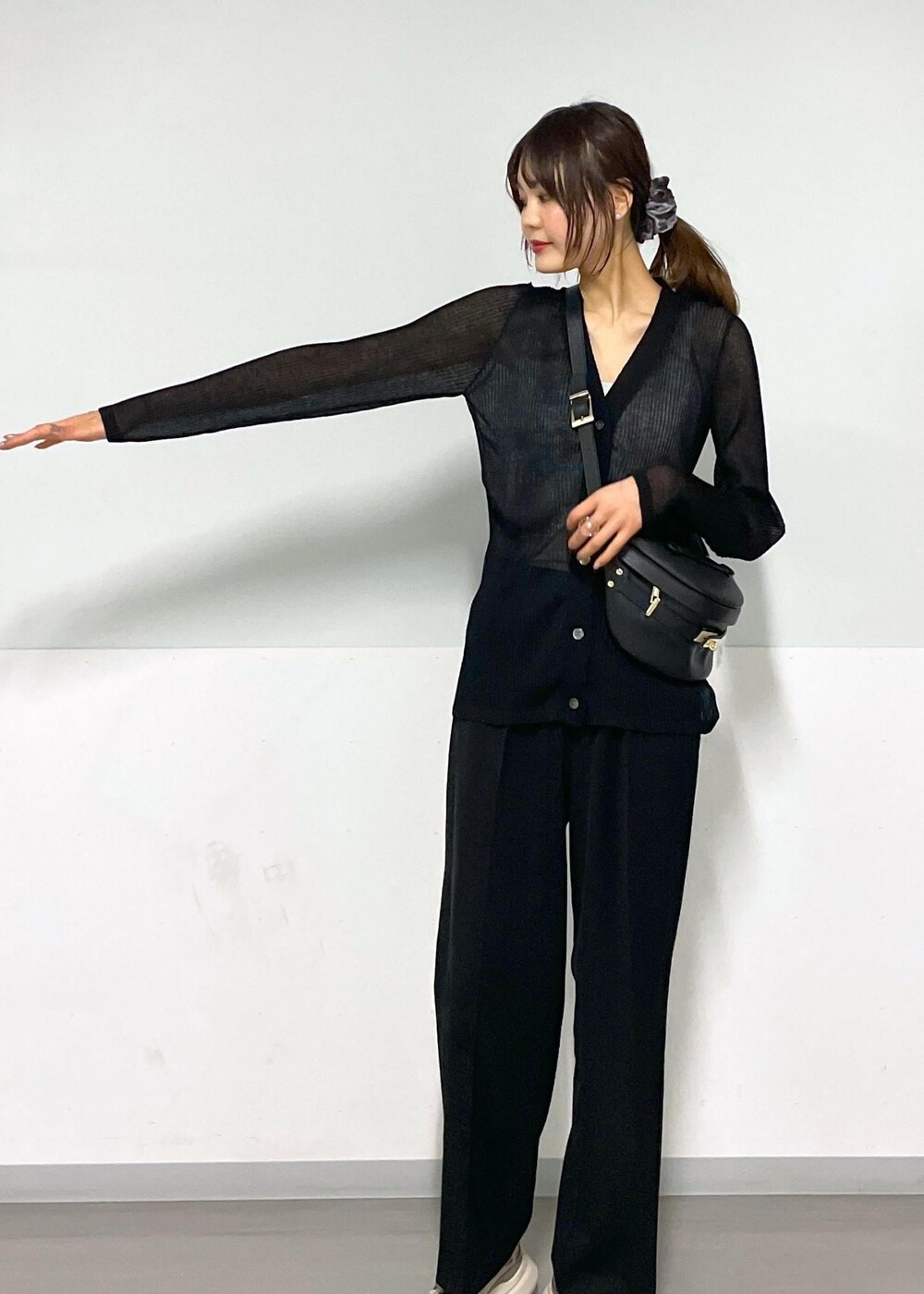 グレー系のタンクトップ、ブラック系のボディバッグ/ウエストポーチ、ブラック系のカーディガン/ボレロを着用したレディースの春コーディネートの5枚目の写真