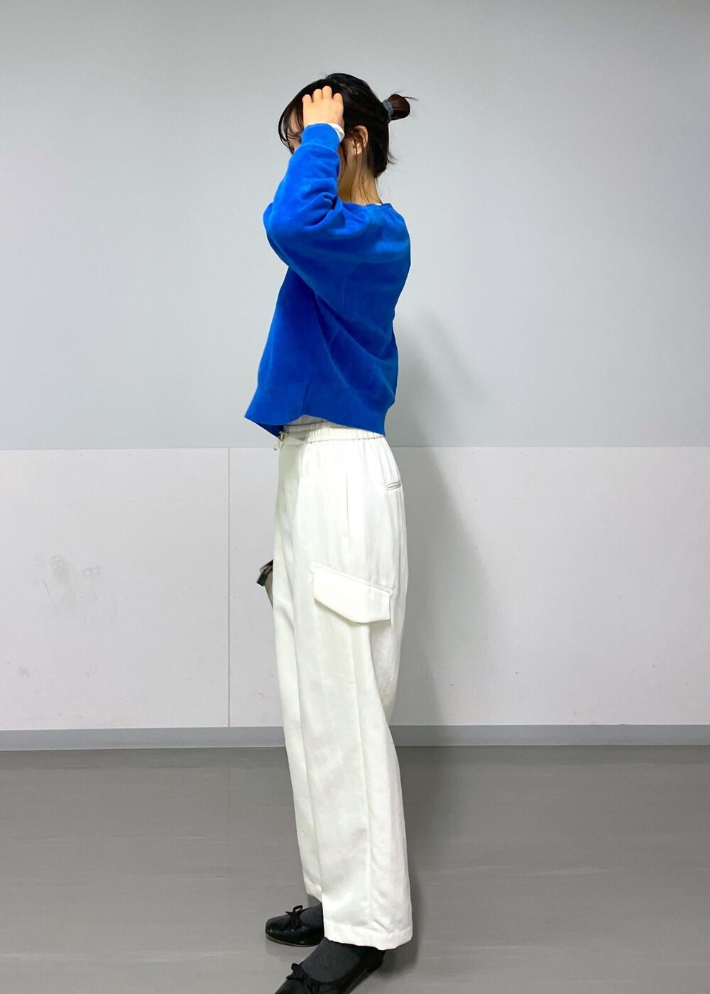 ブルー系のニット/セーター、ホワイト系のカーゴパンツ、ホワイト系のTシャツ/カットソーを着用したレディースの冬コーディネートの4枚目の写真