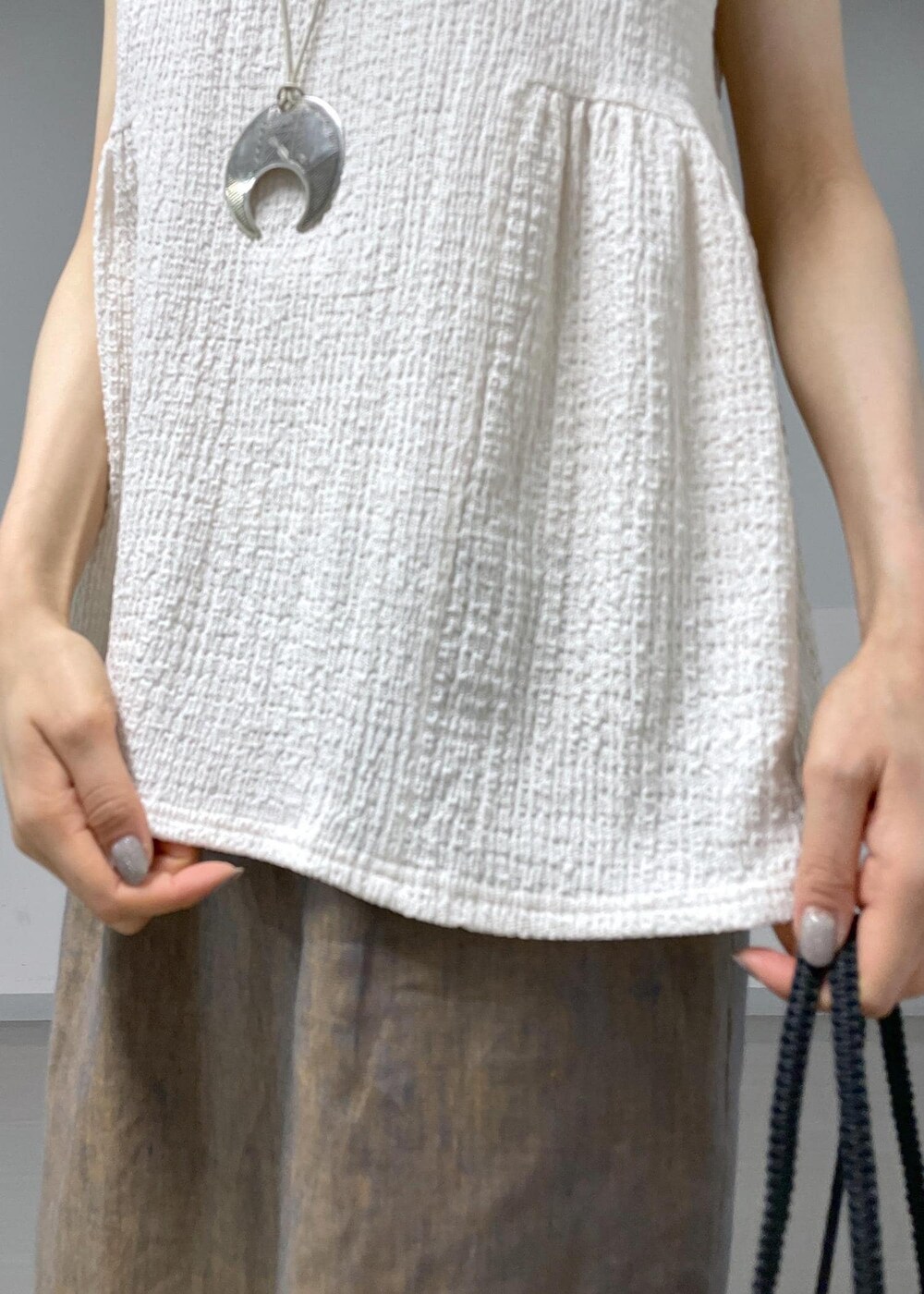 ホワイト系のTシャツ/カットソー、ブラック系のサンダル、ブラック系のトートバッグを着用したレディースの夏コーディネートの7枚目の写真