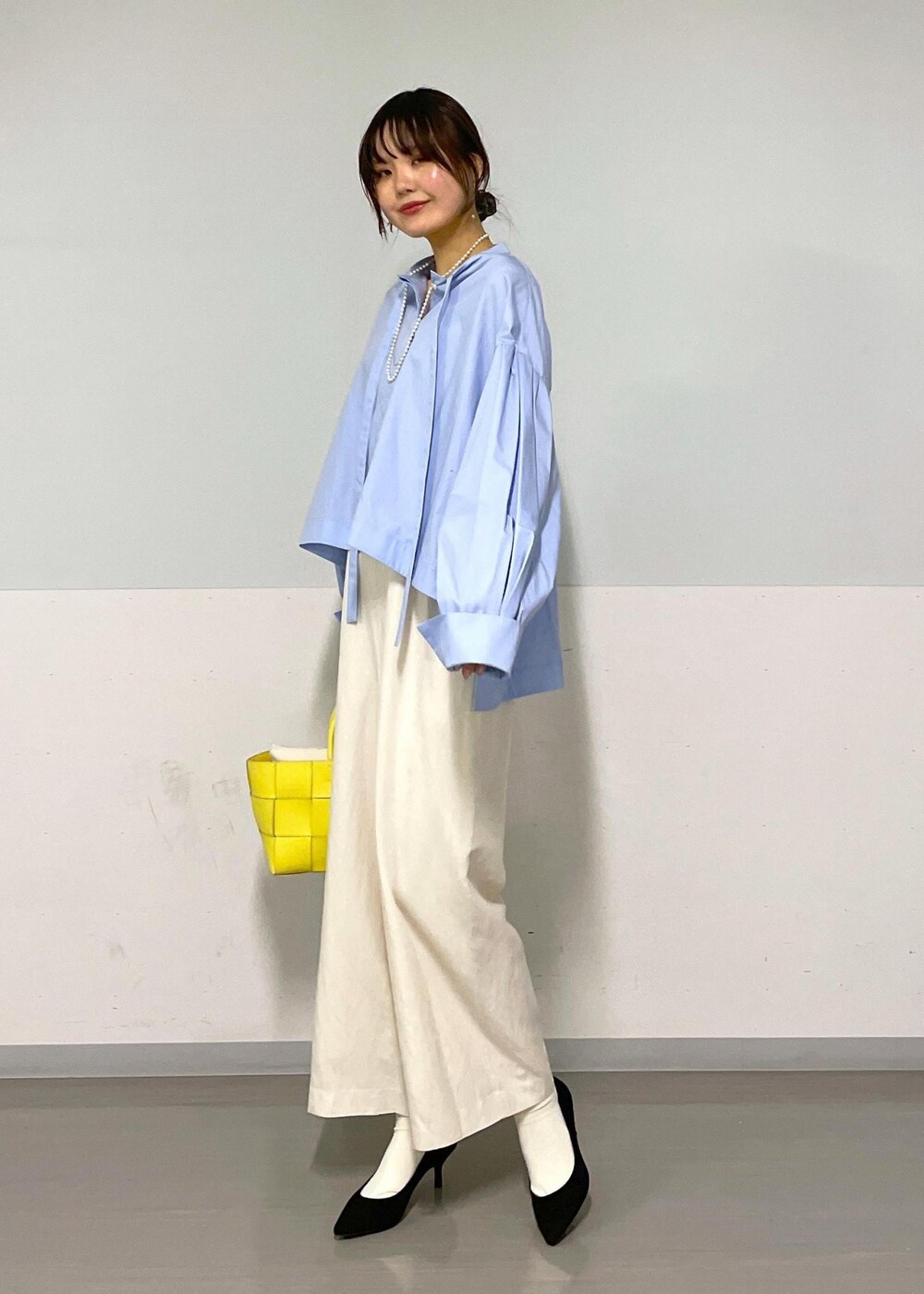 ブルー系のシャツ/ブラウス、イエロー系のトートバッグ、ホワイト系のつなぎ/オールインワンを着用したレディースの春コーディネートの7枚目の写真