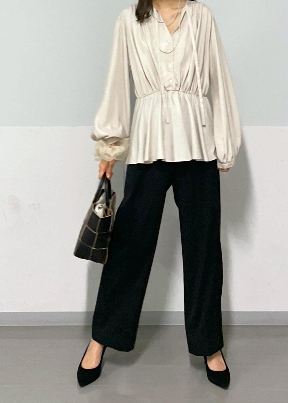 ブラック系のトートバッグ、ブラック系のスラックス、ベージュ系のシャツ/ブラウスを着用したレディースの春コーディネートの8枚目の写真