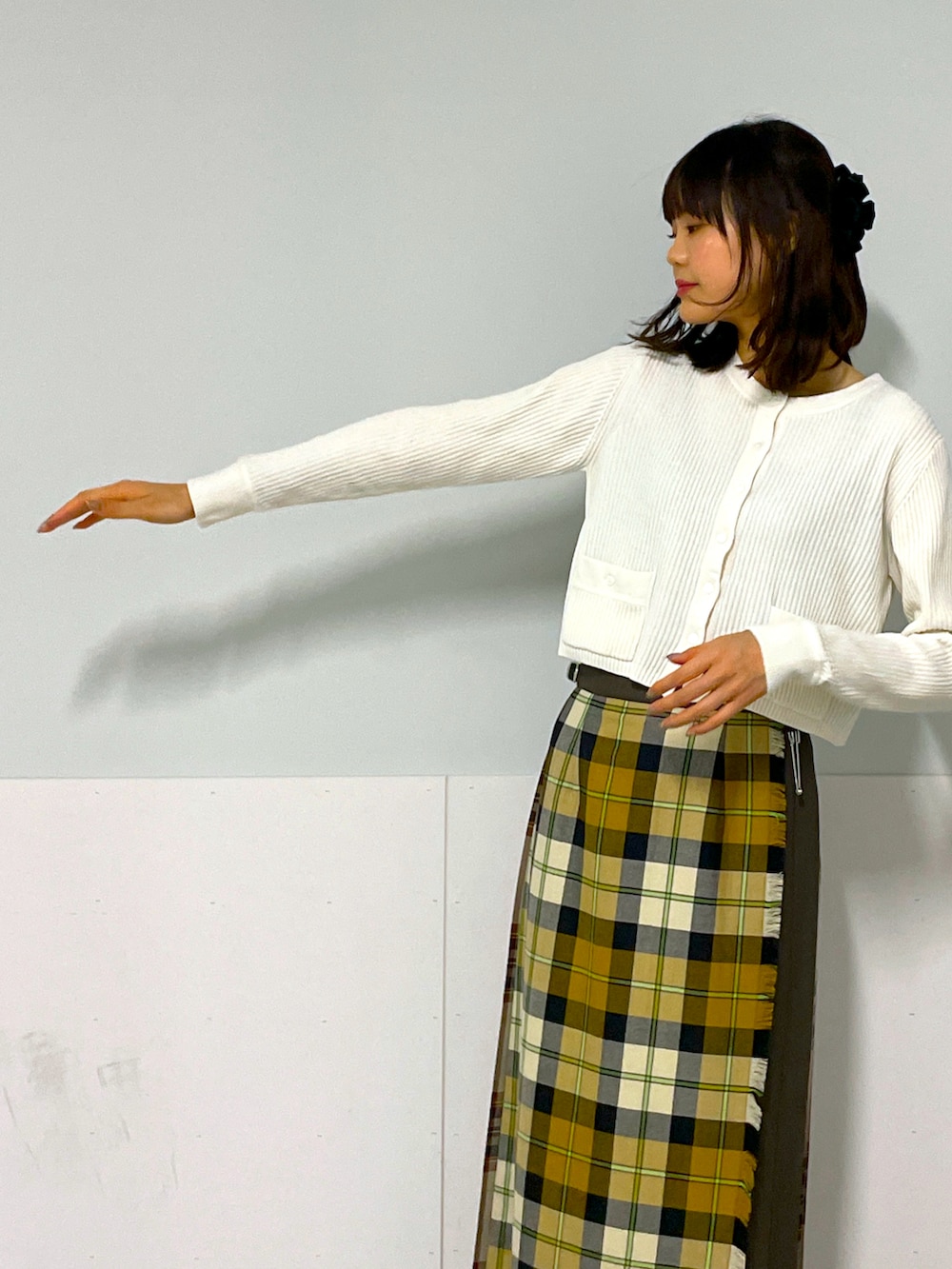 ホワイト系のカーディガン/ボレロ、イエロー系のスカート、ブラック系のシューズを着用したレディースの冬コーディネートの4枚目の写真