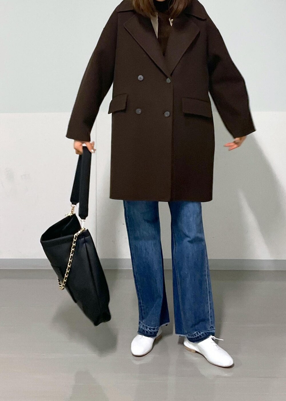 ブラウン系のピーコート、ブラック系のトートバッグ、ブラウン系のTシャツ/カットソーを着用したレディースの冬コーディネートの10枚目の写真