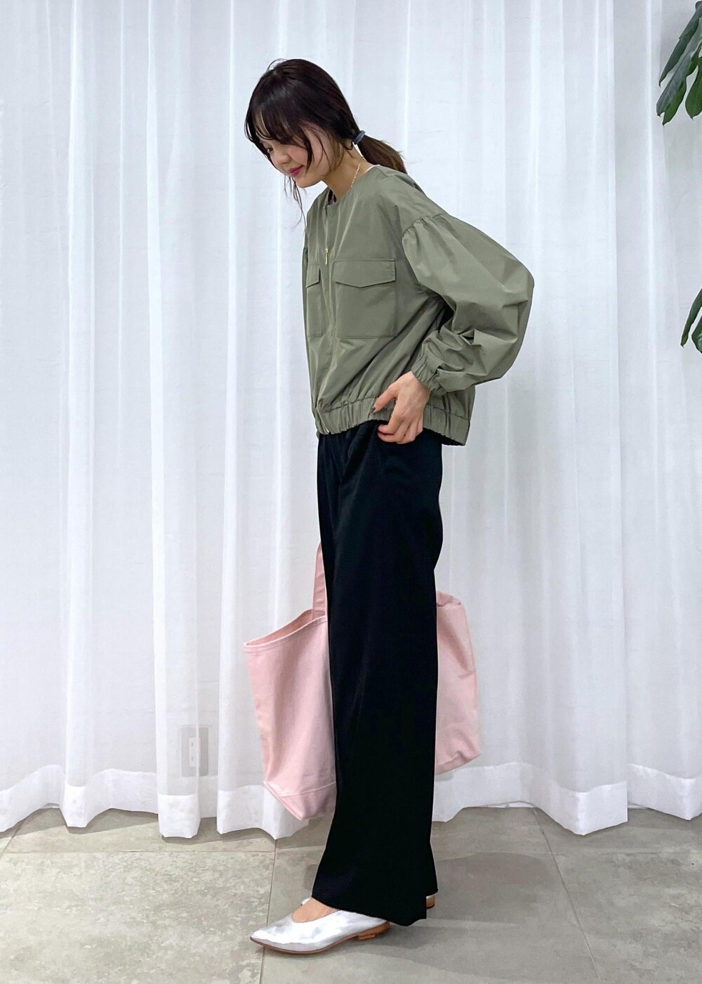 ブラック系のスラックス、グリーン系のブルゾン、シルバー系のパンプスを着用したレディースの冬コーディネートの7枚目の写真