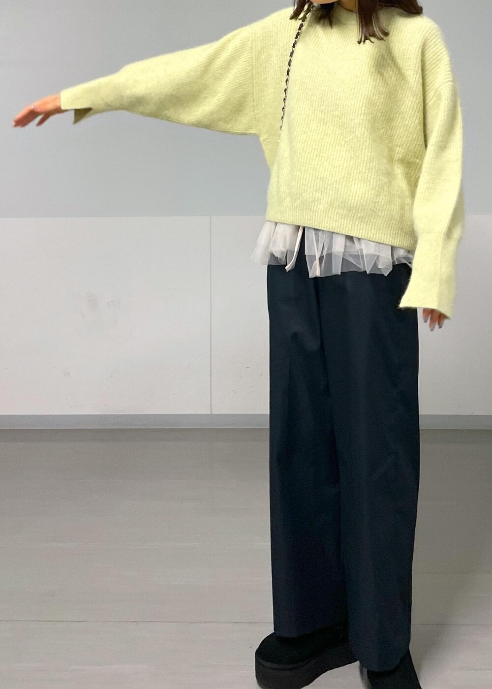 ブラック系のショルダーバッグ、ブラック系のその他パンツ、イエロー系のニット/セーターを着用したレディースの秋コーディネートの6枚目の写真