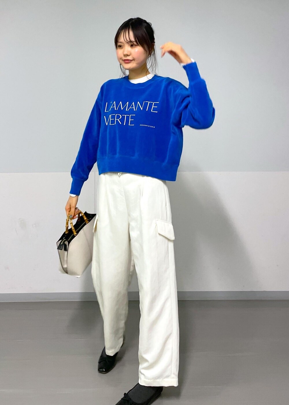 ブルー系のニット/セーター、ホワイト系のカーゴパンツ、ホワイト系のTシャツ/カットソーを着用したレディースの冬コーディネートの5枚目の写真