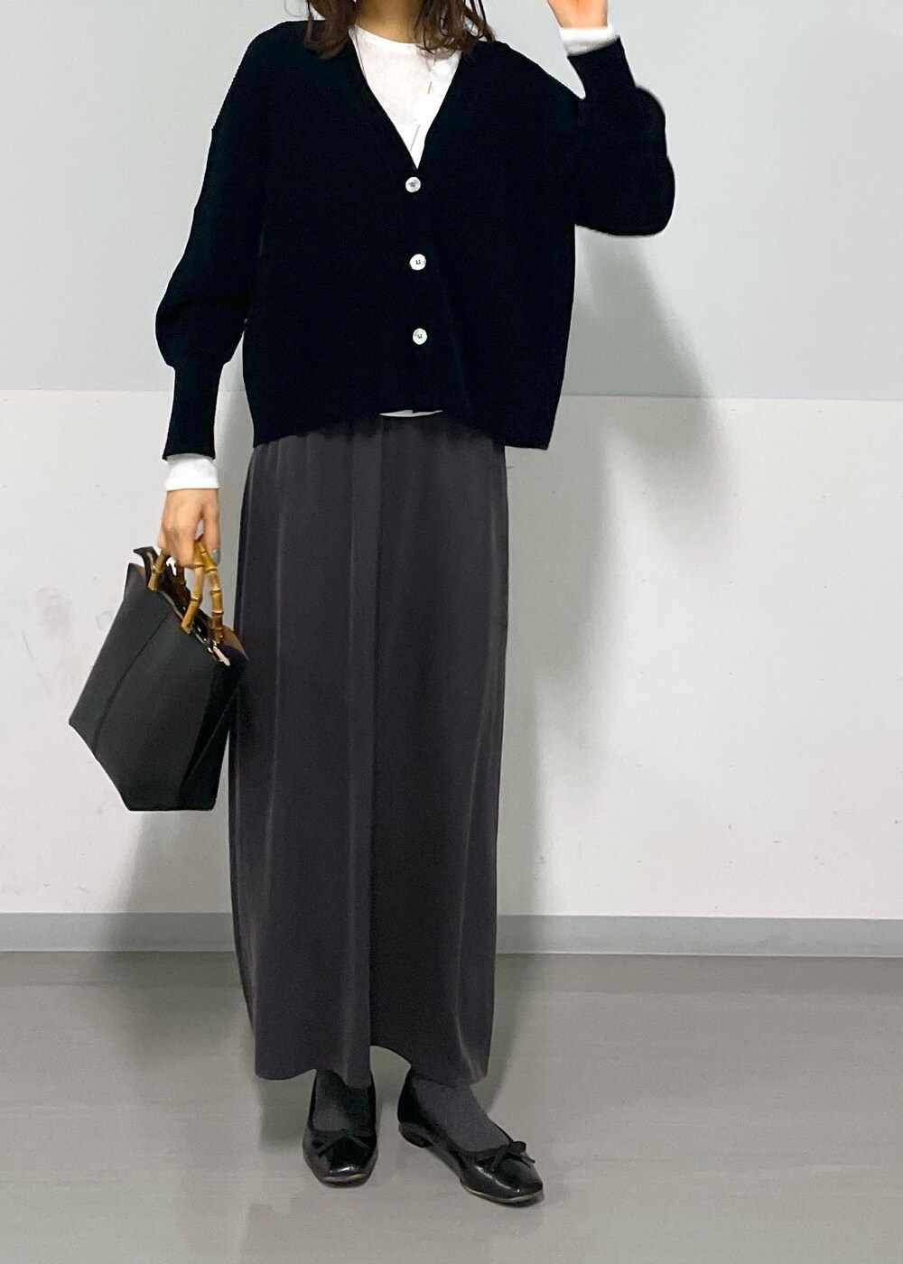 グレー系のスカート、ブラック系のカーディガン/ボレロ、ホワイト系のTシャツ/カットソーを着用したレディースの冬コーディネートの8枚目の写真