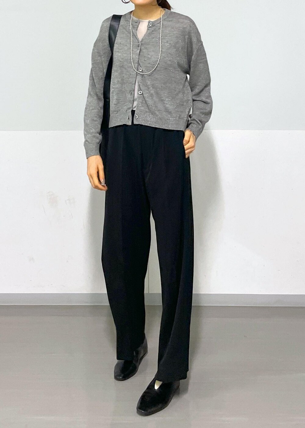 グレー系のカーディガン/ボレロ、グレー系のTシャツ/カットソー、ブラック系のスラックスを着用したレディースの春コーディネートの8枚目の写真