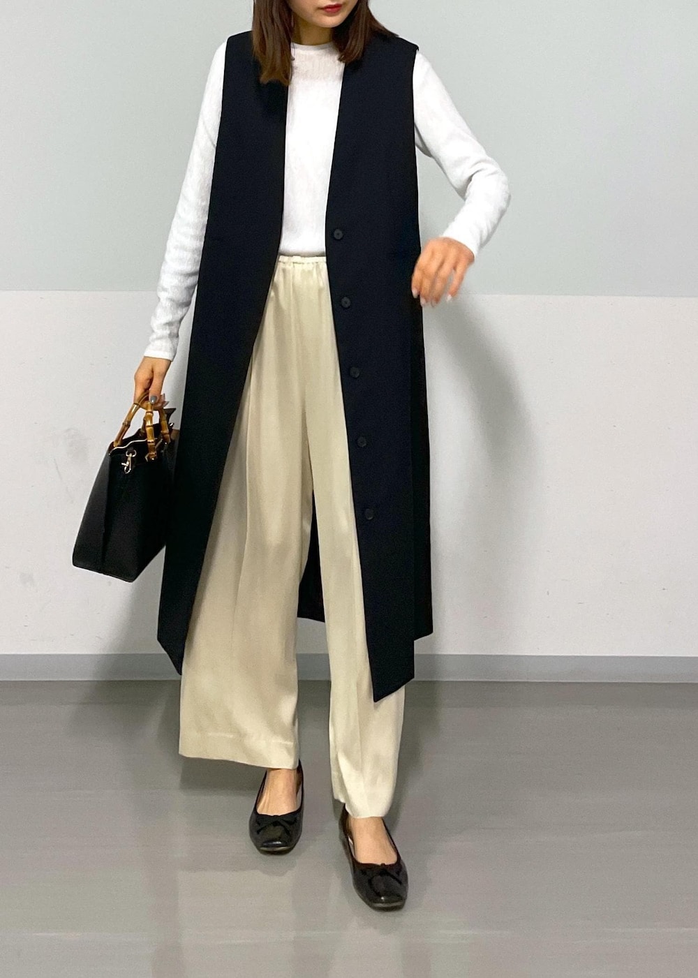 ベージュ系のその他パンツ、ブラック系のジャンパースカート、ホワイト系のTシャツ/カットソーを着用したレディースの冬コーディネートの5枚目の写真