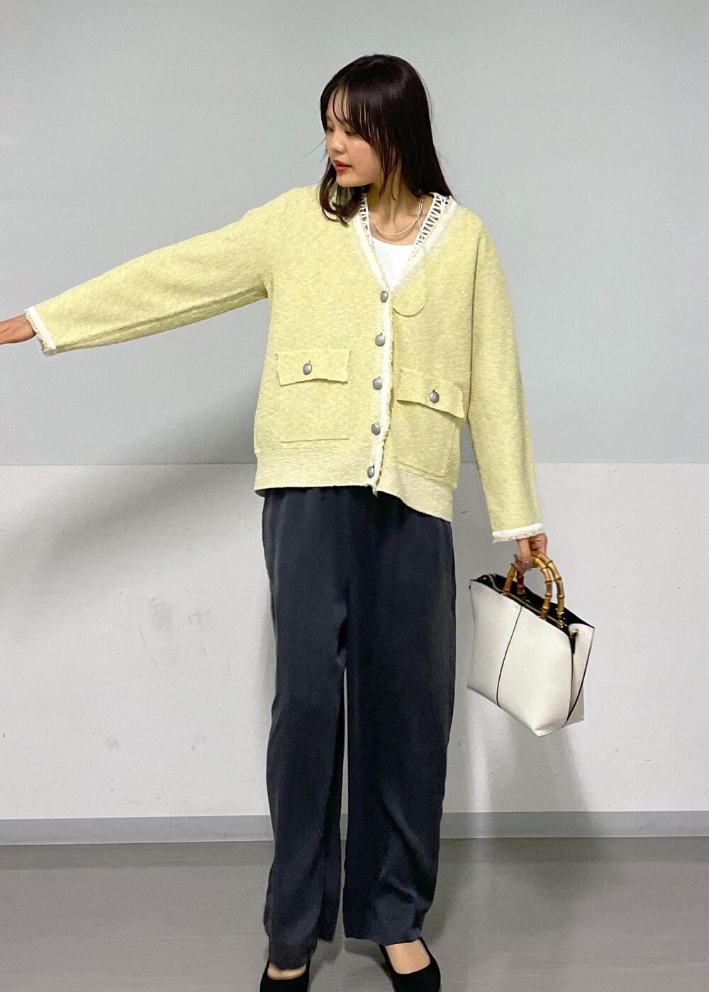 イエロー系のカーディガン/ボレロ、ホワイト系のTシャツ/カットソー、グレー系のその他パンツを着用したレディースの春コーディネートの6枚目の写真