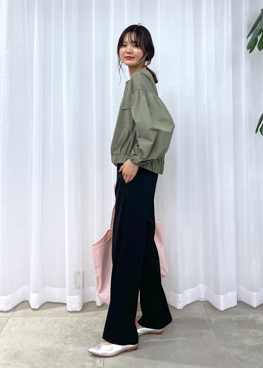 ブラック系のスラックス、グリーン系のブルゾン、シルバー系のパンプスを着用したレディースの冬コーディネートの8枚目の写真