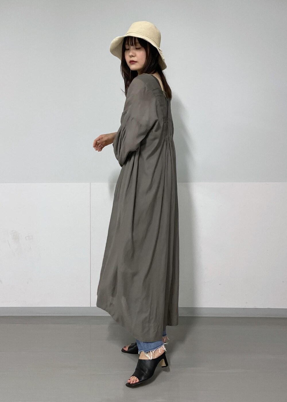 ブラック系のショルダーバッグ、グリーン系のタンクトップ、グレー系のワンピースを着用したレディースの夏コーディネートの2枚目の写真