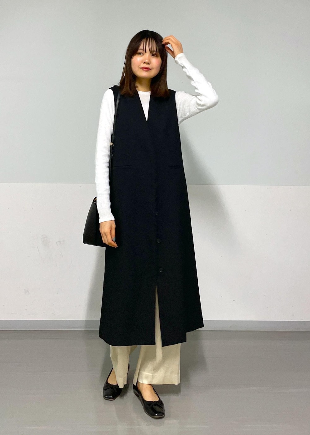 ベージュ系のその他パンツ、ブラック系のジャンパースカート、ホワイト系のTシャツ/カットソーを着用したレディースの冬コーディネートの9枚目の写真