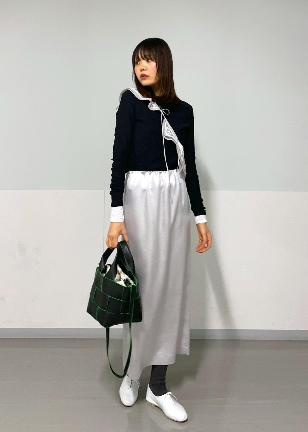 ブラック系のトートバッグ、ホワイト系のその他シューズ、ブラック系のTシャツ/カットソーを着用したレディースの冬コーディネートの5枚目の写真