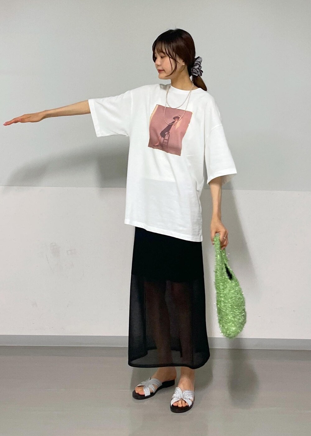 ブラック系のスカート、グリーン系のハンドバッグ、ホワイト系のTシャツ/カットソーを着用したレディースの夏コーディネートの10枚目の写真