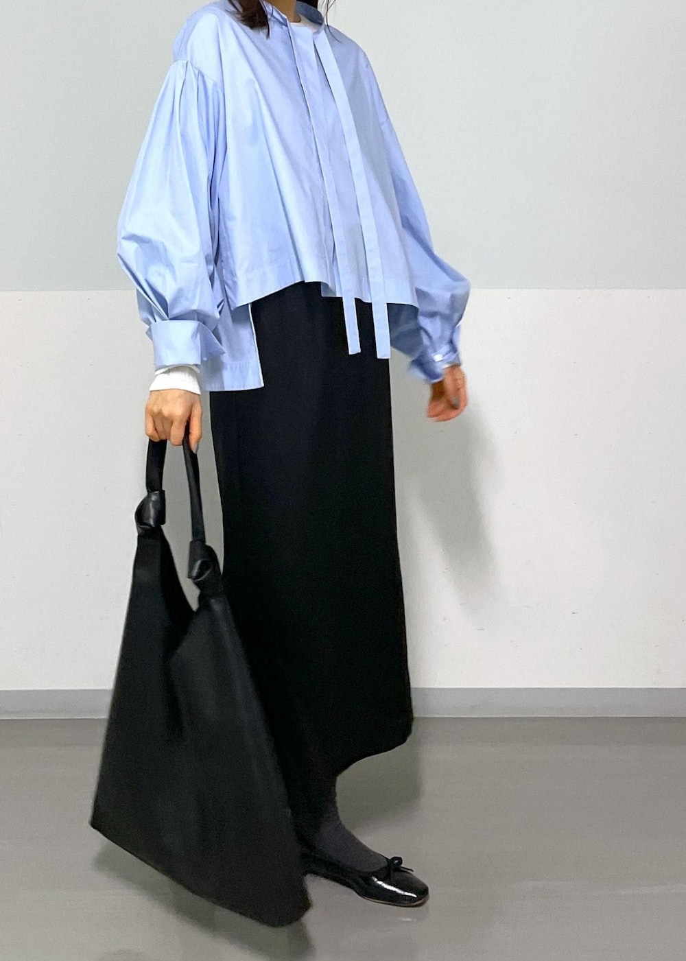 ブルー系のシャツ/ブラウス、ブラック系のトートバッグ、ブラック系のスカートを着用したレディースの冬コーディネートの4枚目の写真