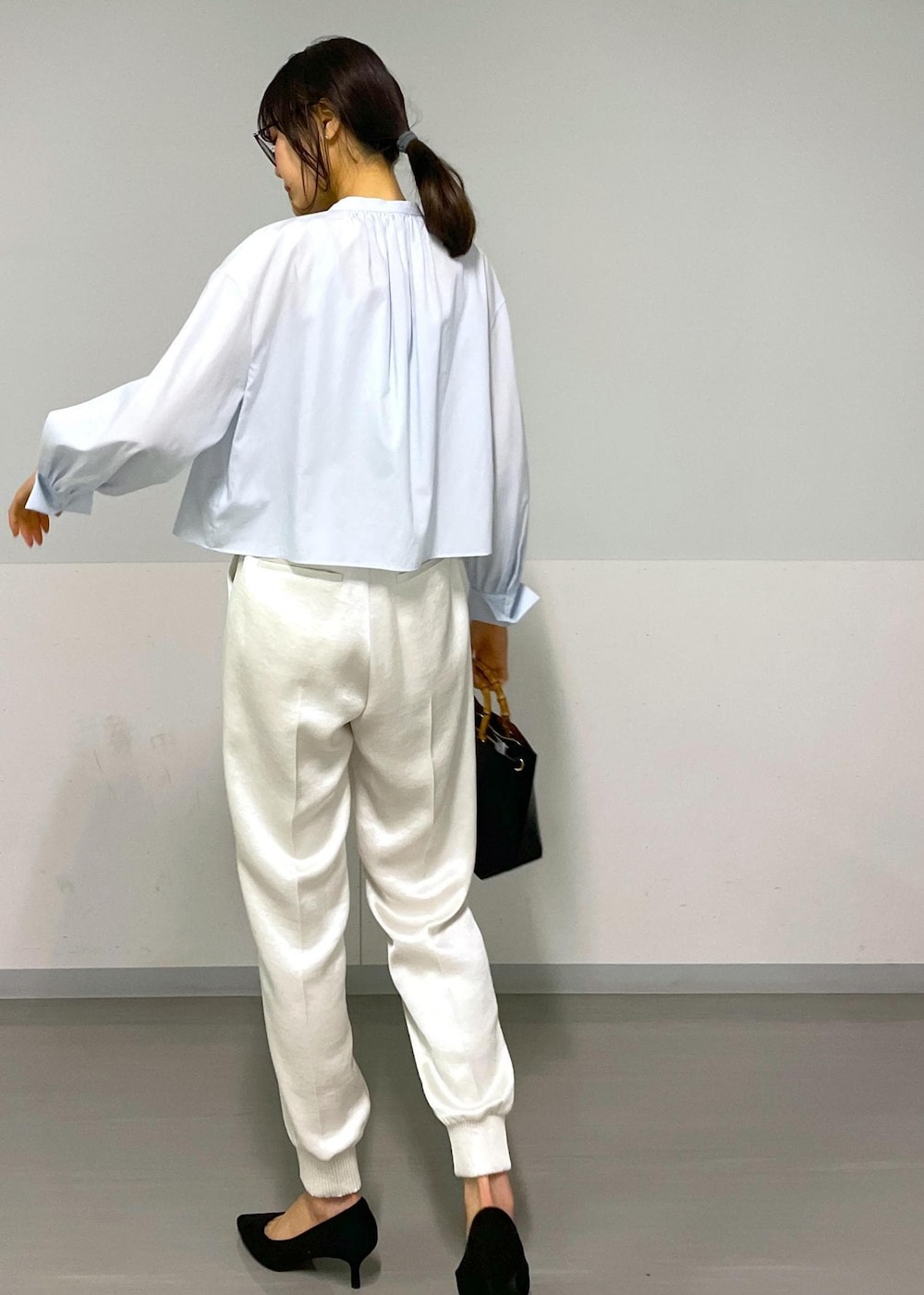 ホワイト系のその他パンツ、ブルー系のシャツ/ブラウス、ブラック系のハンドバッグを着用したレディースの冬コーディネートの7枚目の写真