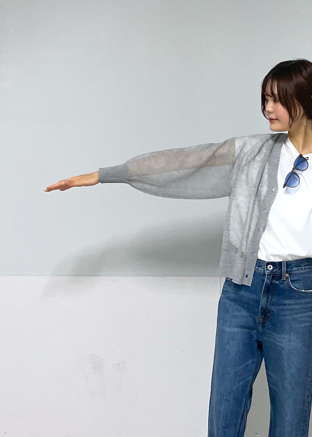 ホワイト系のかごバッグ、グレー系のカーディガン/ボレロ、ホワイト系のTシャツ/カットソーを着用したレディースの春コーディネートの6枚目の写真