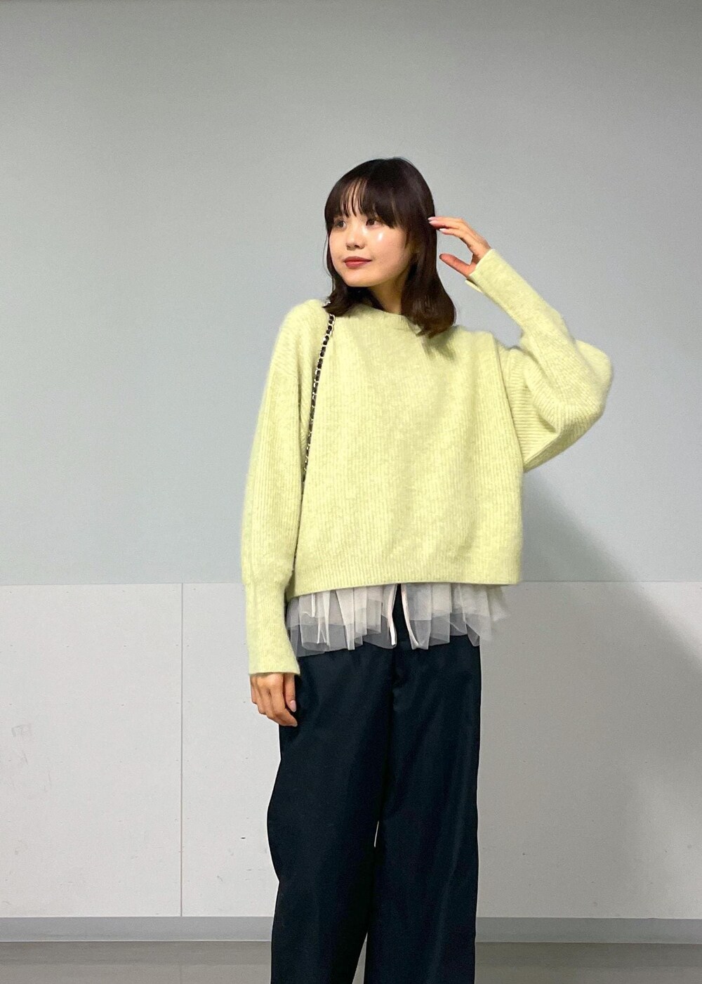 ブラック系のショルダーバッグ、ブラック系のその他パンツ、イエロー系のニット/セーターを着用したレディースの秋コーディネートの3枚目の写真