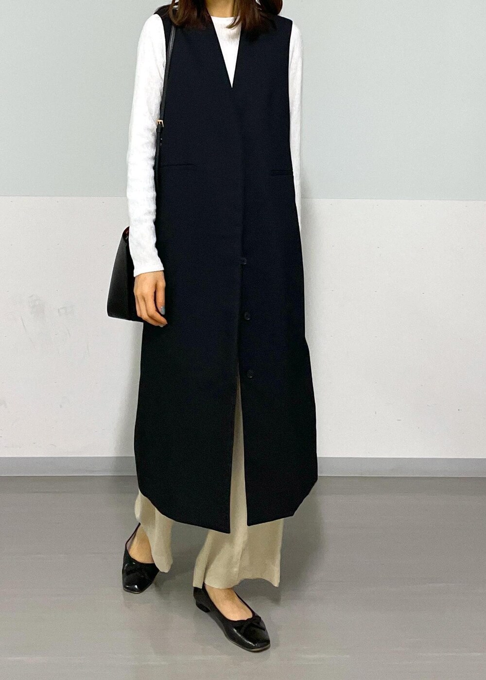 ベージュ系のその他パンツ、ブラック系のジャンパースカート、ホワイト系のTシャツ/カットソーを着用したレディースの冬コーディネートの4枚目の写真