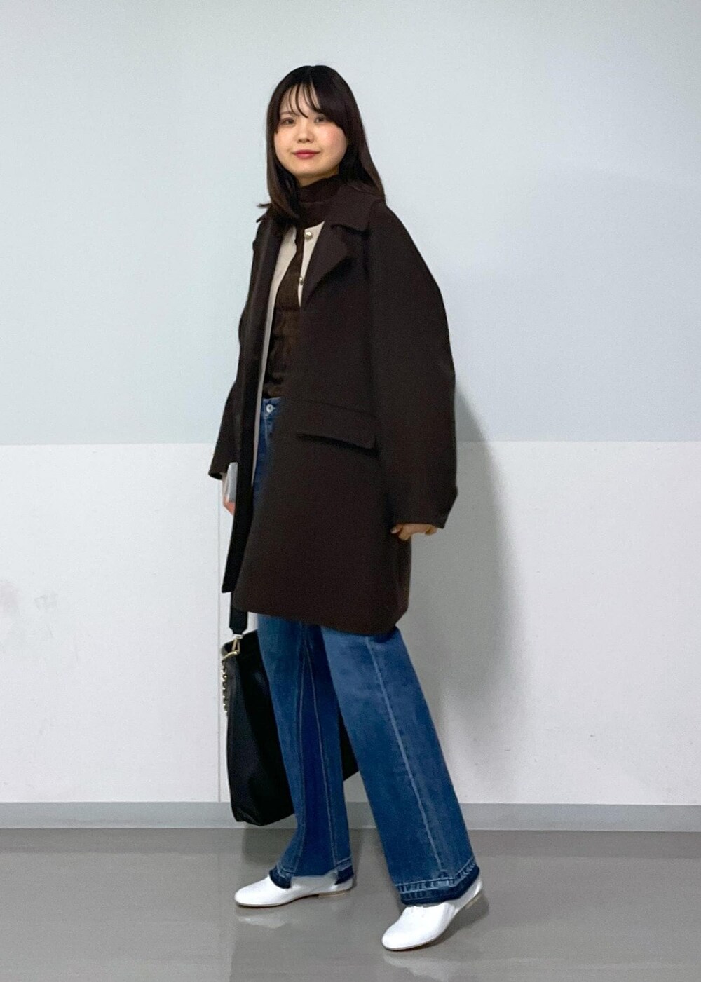 ブラウン系のピーコート、ブラック系のトートバッグ、ブラウン系のTシャツ/カットソーを着用したレディースの冬コーディネートの6枚目の写真