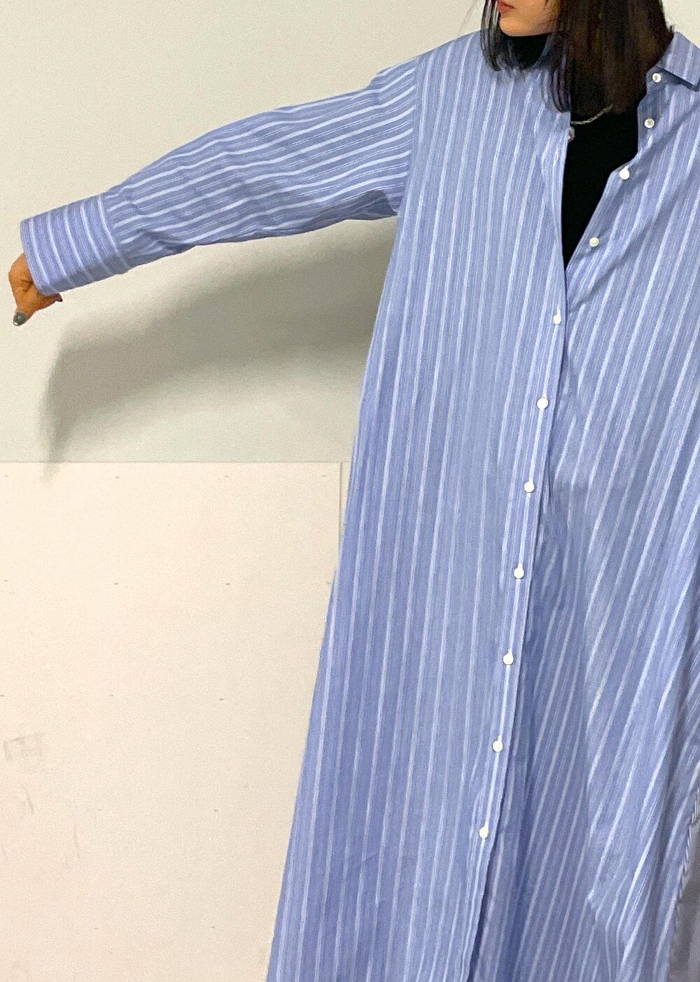 ブラック系のショルダーバッグ、ブルー系のシャツワンピース、ホワイト系のネックレスを着用したレディースの秋コーディネートの8枚目の写真