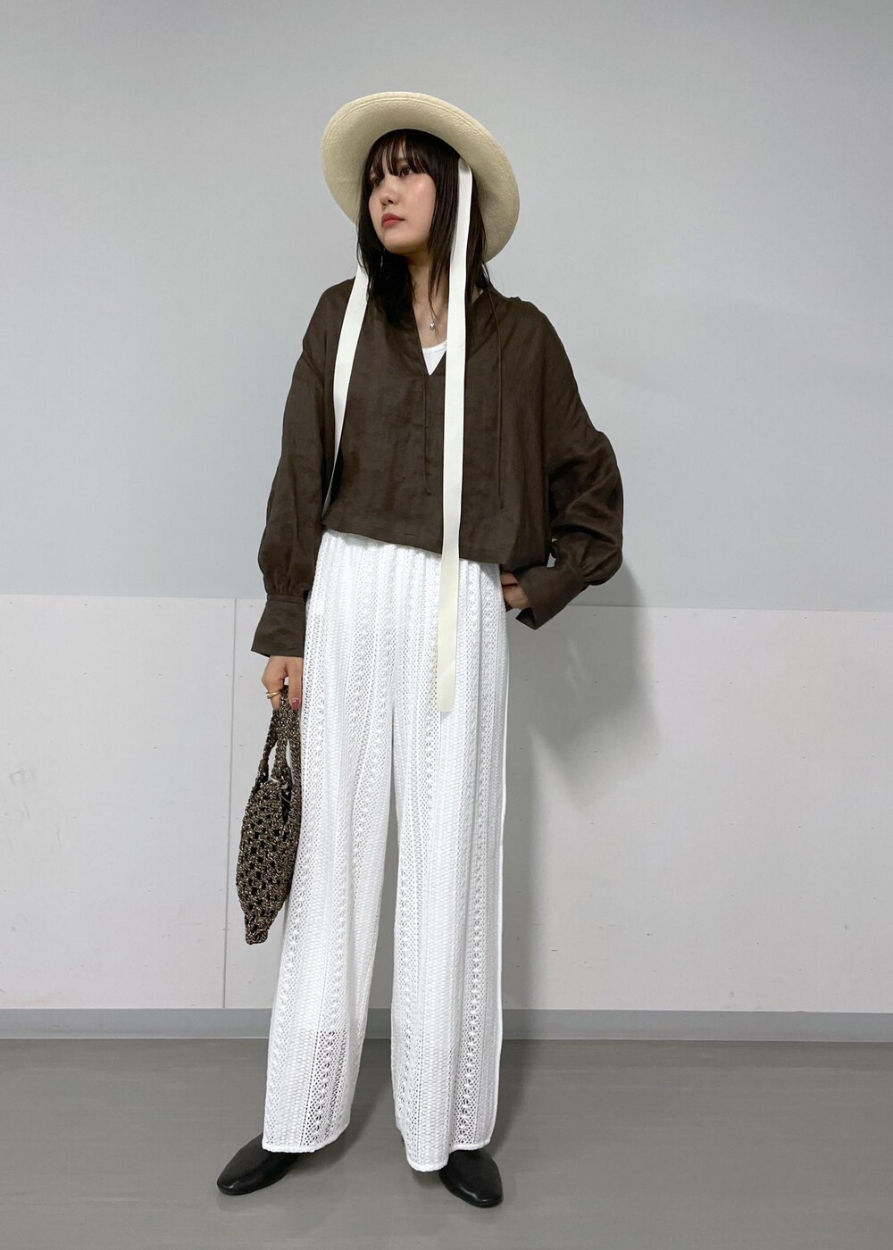 ブラウン系のシャツ/ブラウス、ホワイト系のハンドバッグ、ホワイト系のタンクトップを着用したレディースの春コーディネートの5枚目の写真