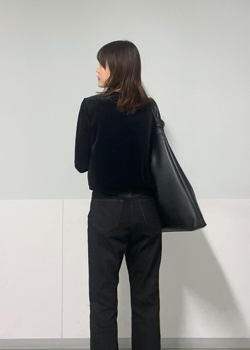 グレー系のTシャツ/カットソー、ブラック系のトートバッグ、グレー系のデニムパンツを着用したレディースの冬コーディネートの10枚目の写真