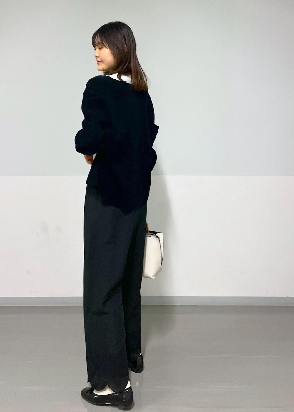 ブラック系のカーディガン/ボレロ、ホワイト系のTシャツ/カットソー、ホワイト系のハンドバッグを着用したレディースの冬コーディネートの3枚目の写真