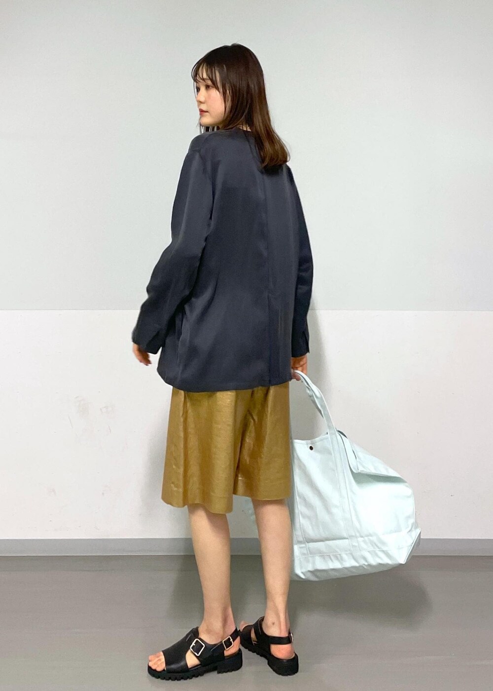 ゴールド系のその他パンツ、グレー系のノーカラージャケット、ブラック系のサンダルを着用したレディースの春コーディネートの3枚目の写真