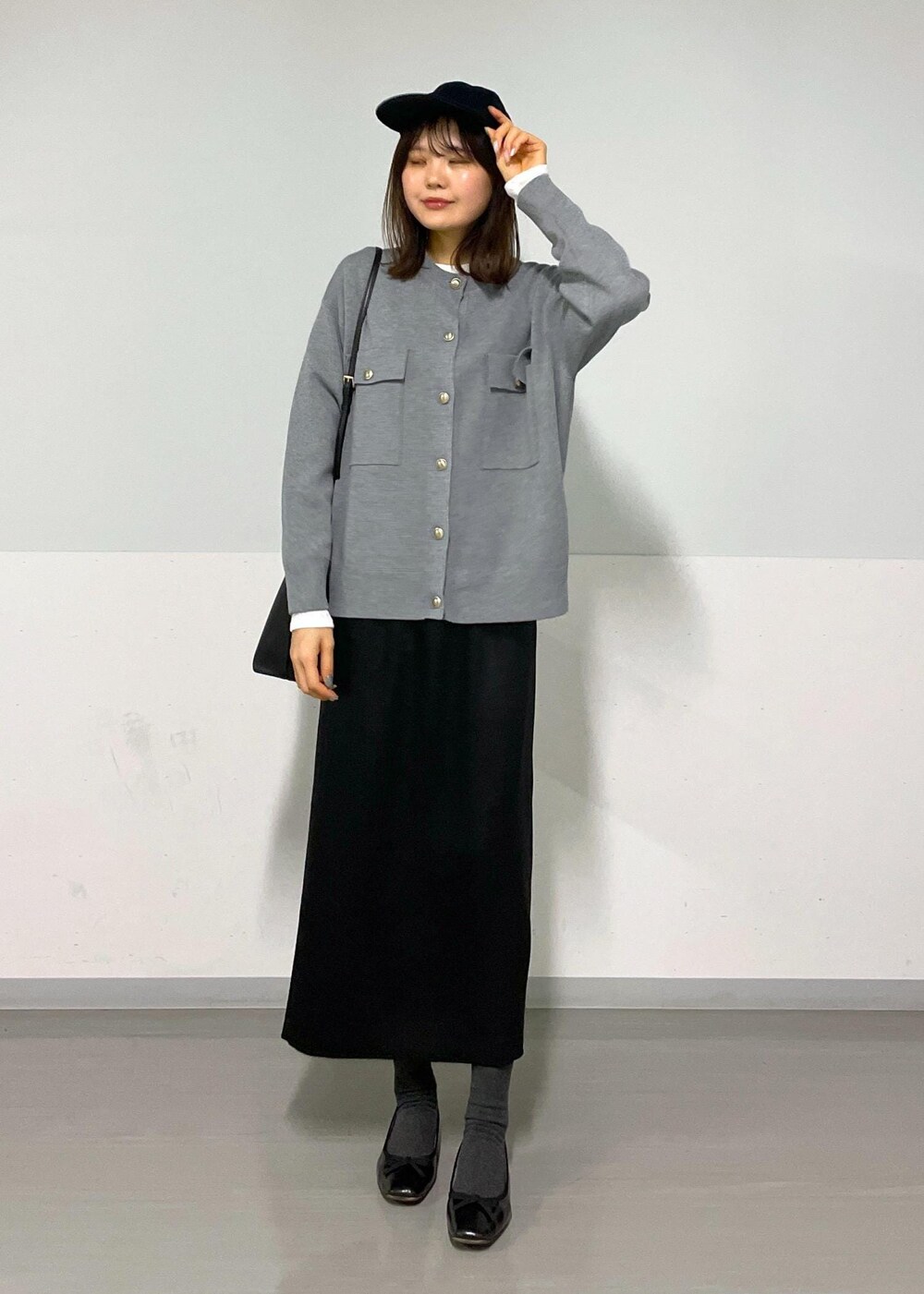 グレー系のカーディガン/ボレロ、ホワイト系のTシャツ/カットソー、ブラック系のハンドバッグを着用したレディースの冬コーディネートの3枚目の写真