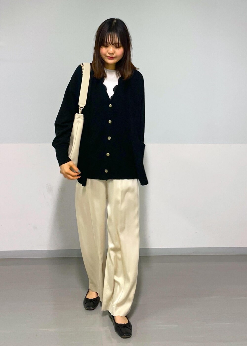 ベージュ系のその他パンツ、ブラック系のカーディガン/ボレロ、ベージュ系のトートバッグを着用したレディースの冬コーディネートの9枚目の写真