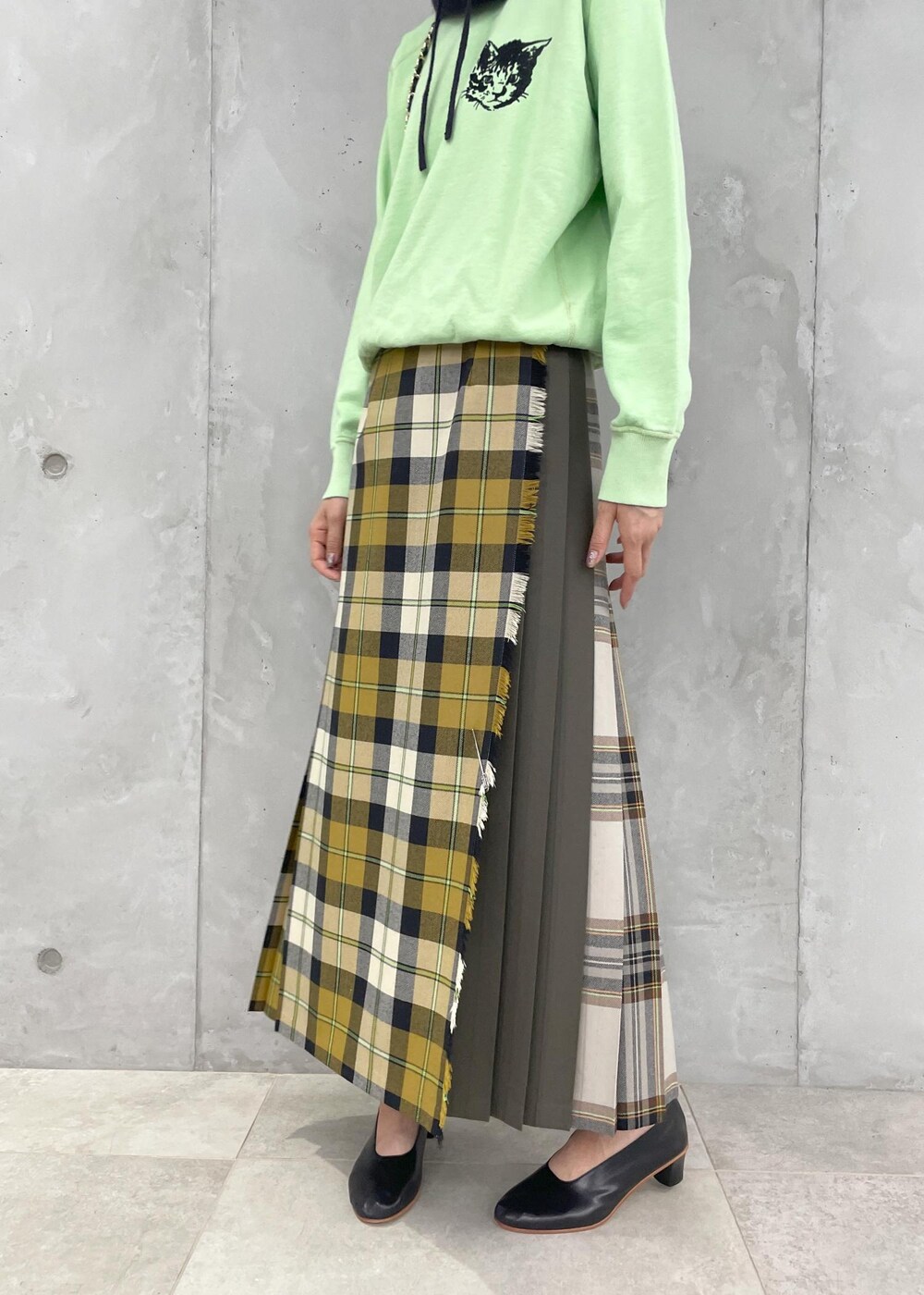イエロー系のスカート、グリーン系のスウェット、ブラック系のショルダーバッグを着用したレディースの夏コーディネートの6枚目の写真
