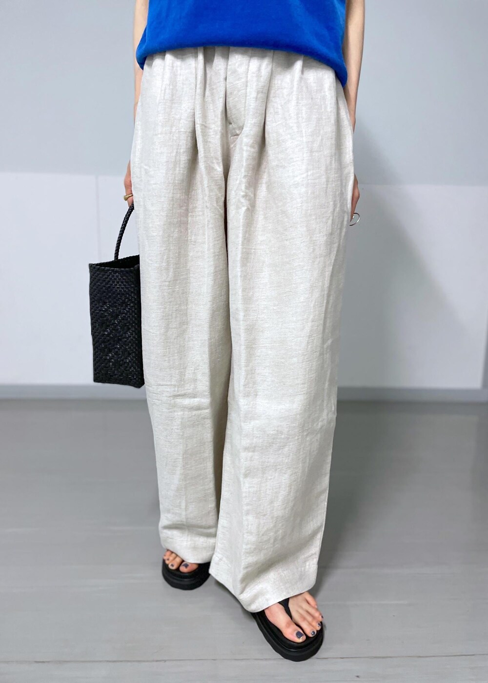 ブラック系のかごバッグ、ホワイト系のスラックス、ホワイト系のテーラードジャケットを着用したレディースの春コーディネートの8枚目の写真