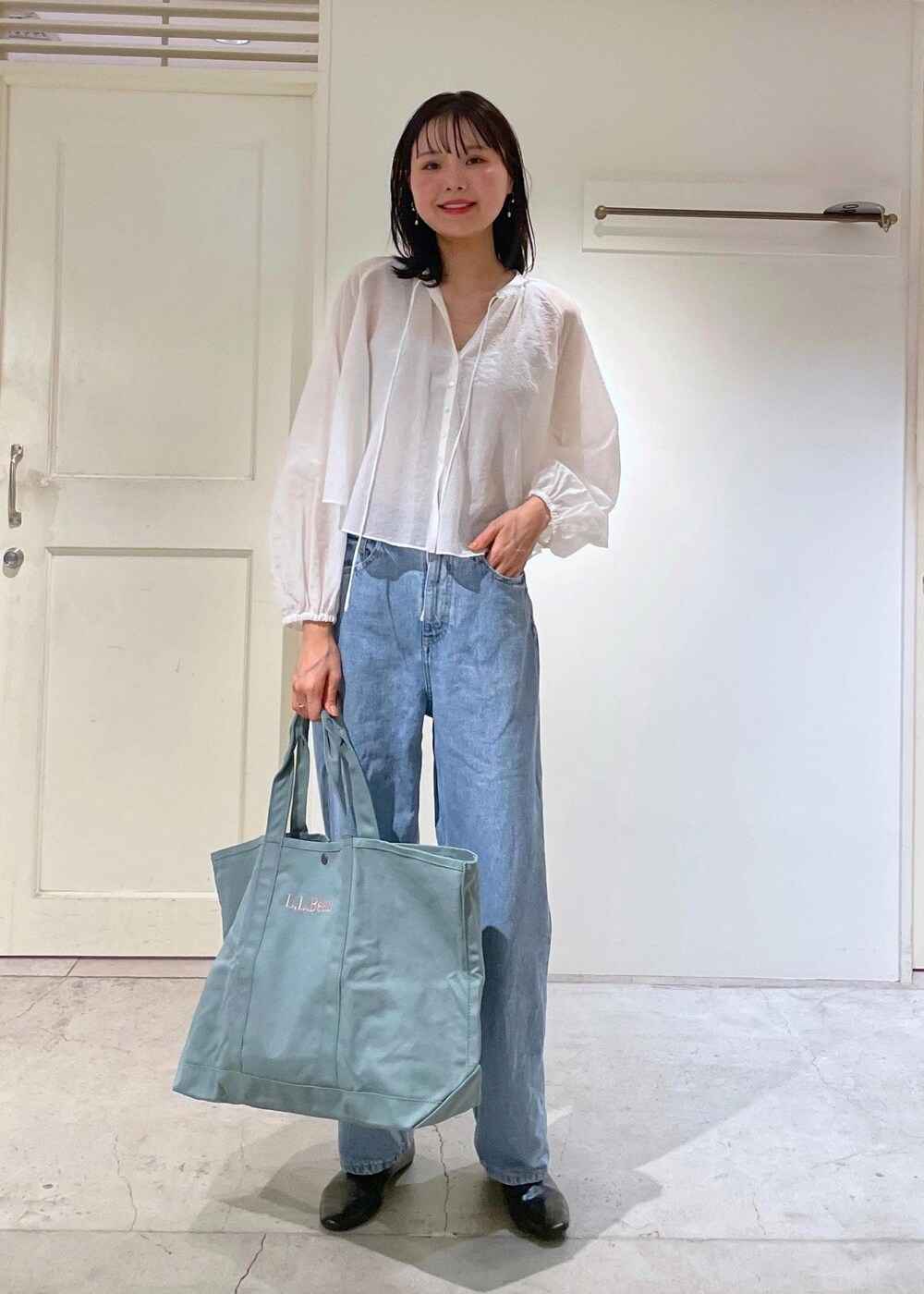 グレー系のタンクトップ、ホワイト系のシャツ/ブラウス、ブルー系のデニムパンツを着用したレディースの夏コーディネートの2枚目の写真