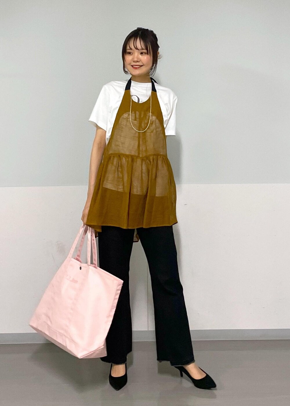 グレー系のデニムパンツ、ホワイト系のTシャツ/カットソー、ブラウン系のベストを着用したレディースの春コーディネートの3枚目の写真