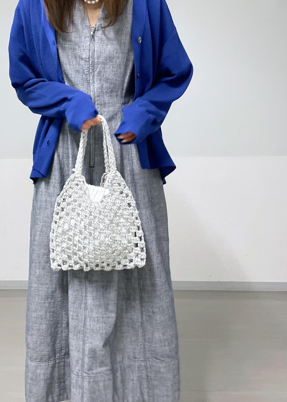 ブラック系のサンダル、ホワイト系のハンドバッグ、ブルー系のカーディガン/ボレロを着用したレディースの夏コーディネートの5枚目の写真