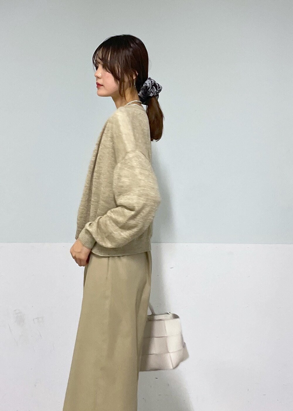 ホワイト系のトートバッグ、ベージュ系のスカート、ベージュ系のカーディガン/ボレロを着用したレディースの夏コーディネートの8枚目の写真