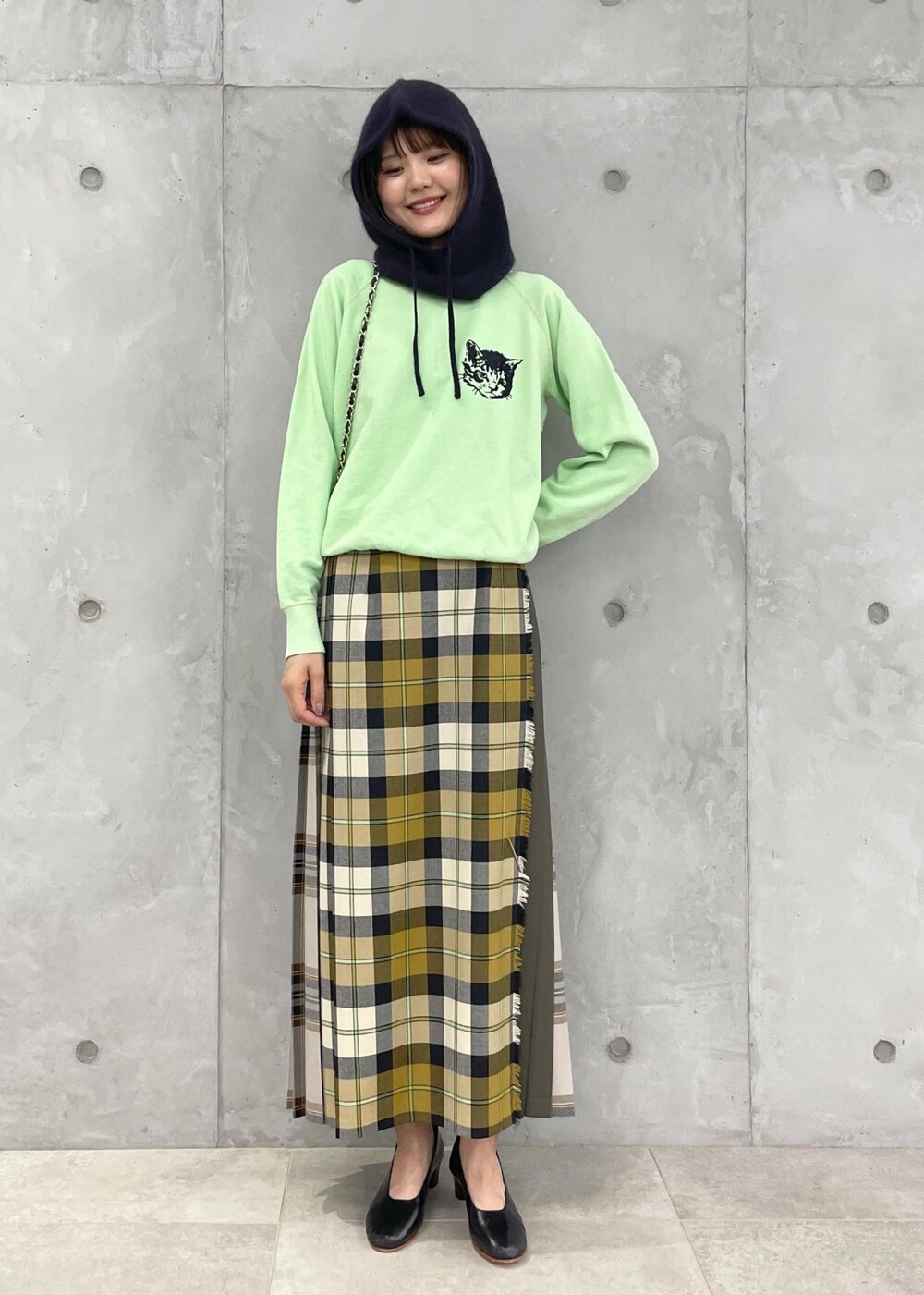 イエロー系のスカート、グリーン系のスウェット、ブラック系のショルダーバッグを着用したレディースの夏コーディネートの8枚目の写真