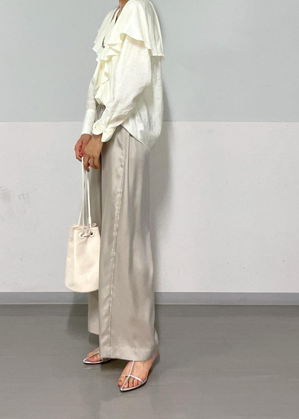 ホワイト系のシャツ/ブラウス、シルバー系のサンダル、ホワイト系のショルダーバッグを着用したレディースの夏コーディネートの3枚目の写真