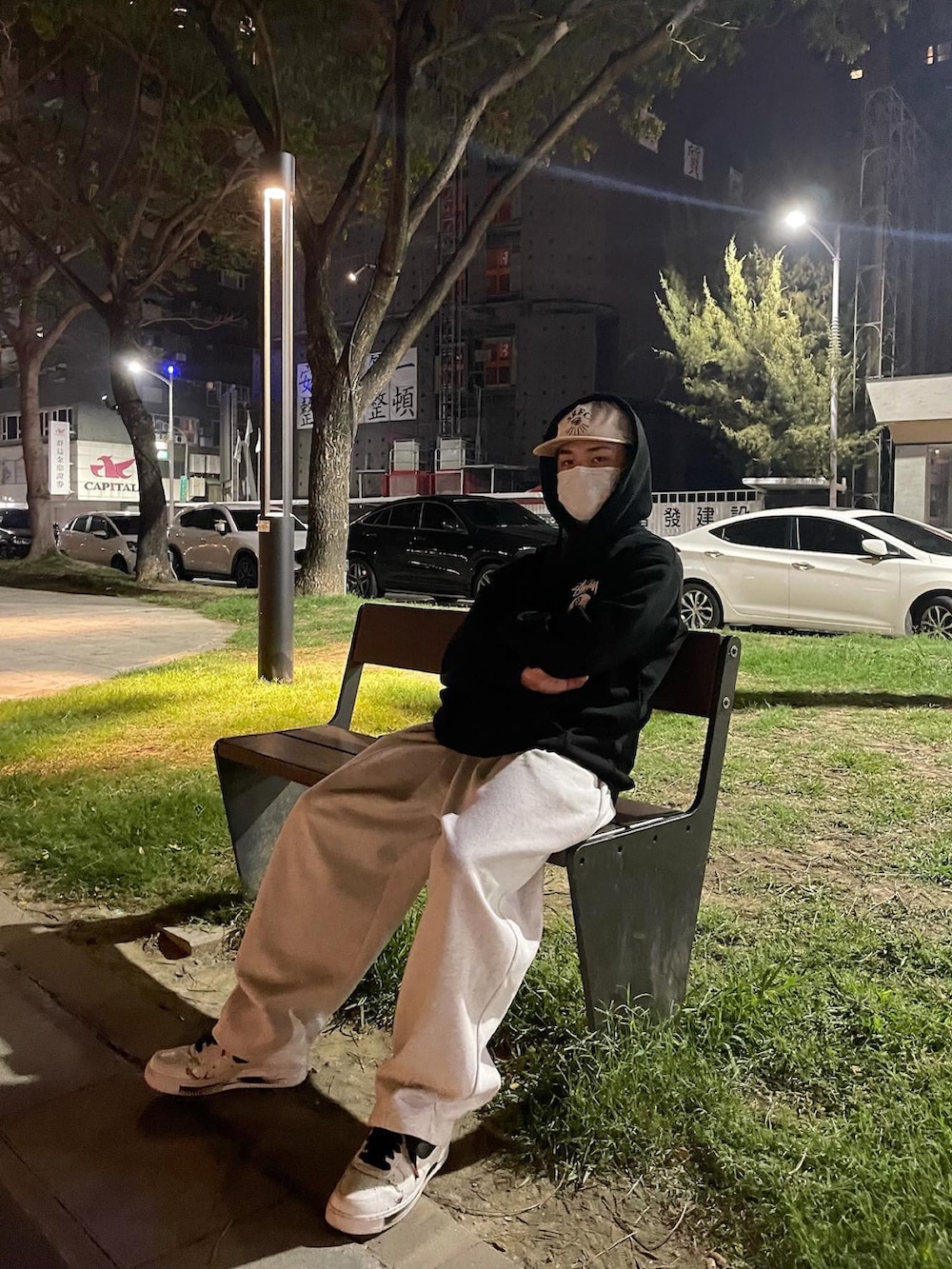 ブラック系のパーカー、ホワイト系のスニーカーを着用したメンズの春コーディネートの2枚目の写真