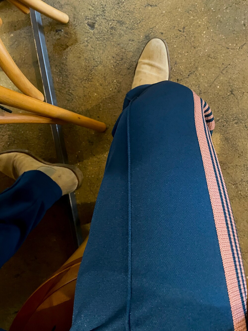グレー系のチェスターコート、グリーン系のその他パンツ、ブラック系のパーカーを着用したメンズの冬コーディネートの3枚目の写真