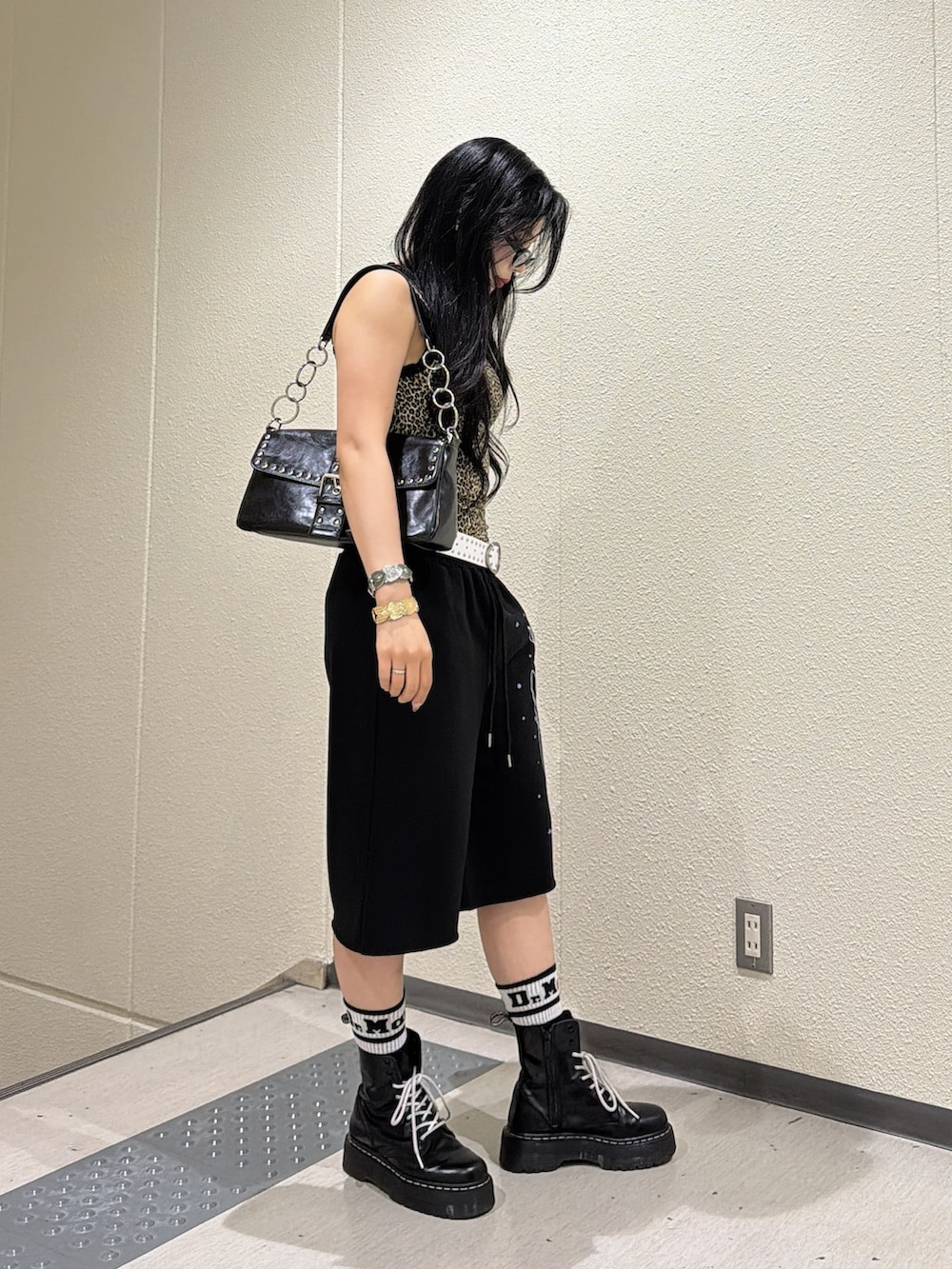 ブラウン系のタンクトップ、ブラック系のその他パンツ、ブラック系のハンドバッグを着用したレディースの夏コーディネートの2枚目の写真