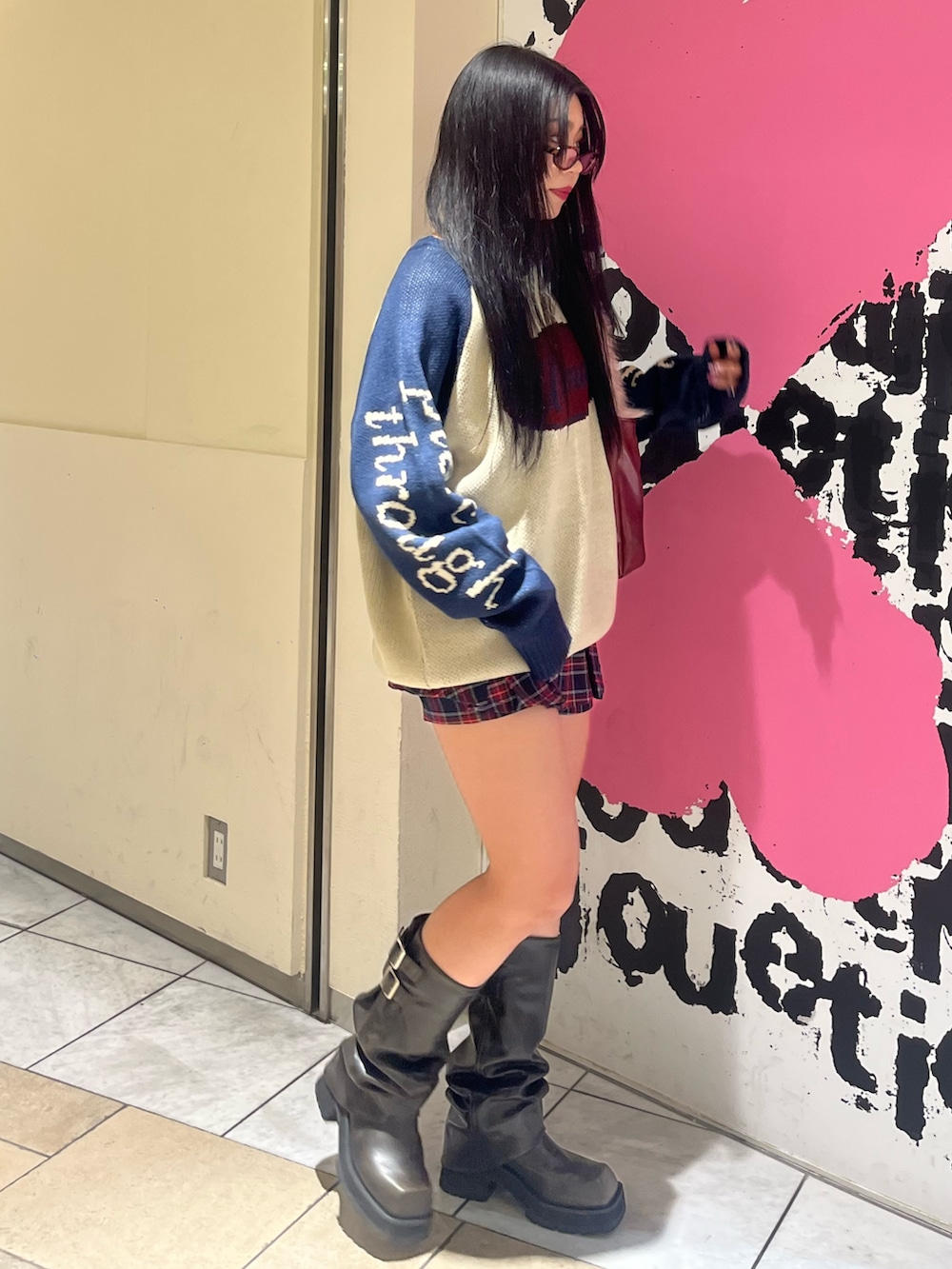 ホワイト系のニット/セーター、ブルー系のスカート、レッド系のハンドバッグを着用したレディースの冬コーディネートの2枚目の写真